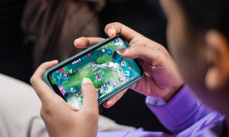 Someone holding a mobile phone horizontal playing a game